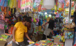 People buy Holi decorative items at a market area ahead of the Holi festival in Siliguri,...