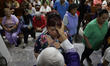 A priest places ashes on the foreheads of residents of San Lorenzo Tezonco in Mexico City,...