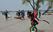 Some unicycle performer plays hockey with mates at a park in Harbin, Heilongjiang province...