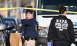 NYPD crime scene unit investigators photograph, mark shell casings, and collect evidence i...