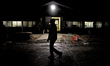 A backstretch employee walks past a barn entrance before sunrise at Woodbine Racetrack in...
