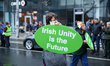 A parade participant carries a sign that says ''Irish Unity is the Future'' while on the p...