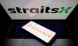 The Binance logo appears on a smartphone screen, and the StraitsX logo appears on a comput...