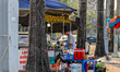 A man prepares food at a street food stall set up along a busy sidewalk in Thanh Hoa, Viet...