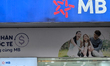 The logo of MB Bank is displayed above a promotional banner featuring a smiling family out...