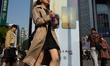 Tourists walk in front of Huawei Pura X foldable cell phone advertising in Shanghai, China...