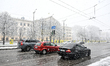 Three cars stand at traffic lights during a snowfall in Zaporizhzhia, Ukraine, on April 9,...
