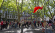 A person drinks water while carrying a large Portugal flag during the ''April 25th Parade...