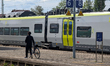 A man with a bicycle stands on the platform next to an Agilis regional train at Plattling...