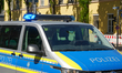 A German police van with activated blue lights is stationed during a police operation in t...