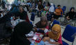 Dozens of patients with disabilities queue for health services at the disability posyandu...