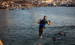 Palestinians jump into the Mediterranean Sea during the hot weather in Gaza City, on May 9...
