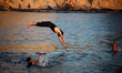 Palestinians jump into the Mediterranean Sea during the hot weather in Gaza City, on May 9...