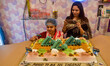 A baker in Kolkata, India, on May 10, 2025, stands in front of a custom cake made in honor...