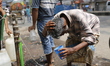 A rickshaw puller splashes water on his head to find relief during a heatwave in Dhaka, Ba...