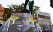A woman holds the portrait of a Palestinian journalist killed in Gaza by Israel, along wit...