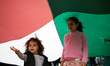Two girls play under a giant Palestinian flag. A commemoration of the 1948 'Nakba' (catast...
