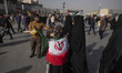 A young veiled Iranian girl wears an Iran flag while participating in a ceremony commemora...