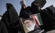A veiled Iranian woman holds a portrait of Iran's Supreme Leader, Ayatollah Ali Khamenei,...