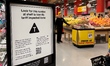 U.S. products with prices affected by tariffs display a ''T'' symbol banner at a grocery i...