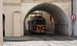 A tram of line 22 emerges from a narrow arched passageway in the historic district of Prag...