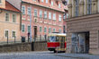 A vintage red and cream tram, number 6921 on line 23, turns past historic buildings in the...
