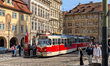 A red and cream tram on line 22 arrives at a station in the heart of Prague's historic old...