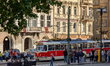 A red and cream tram on line 22 stops at a busy station in Prague's historic city center,...