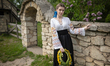 A woman holds a floral crown and wears a vyshyvanka, a Ukrainian embroidered shirt featuri...