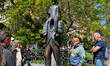 Tourists with a guide stand at the Franz Kafka statue by Jaroslav Rona between the Church...