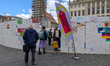 People enter a circular wall of peace decorated with multilingual drawings and peace messa...