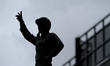 A statue of the late jockey Avelino Gomez stands in silhouette at the front of the grandst...