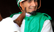Jockey Rafael Hernandez smiles as he rides out of the paddock ahead of the first race at W...