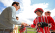 Jockey Sofia Vives hands over a pair of goggles to a young race fan after a win in the thi...