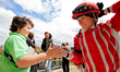 Jockey Sofia Vives receives a high-five from a young race fan after a win in the third rac...