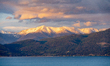 Snow-dusted peaks of the Mission Mountains glow in the last golden light of day as the sun...