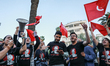 Demonstrators wave national flags of Tunisia and shout slogans during a symbolic visiting...