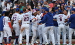 New York Mets player Francisco Lindor (12) is surrounded by teammates after his game-winni...