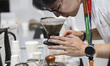 A barista brews coffee for visitors during the World of Coffee Jakarta 2025, held at the J...