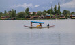 A man rows a boat on the waters of Dal Lake during rainy and cloudy weather in Srinagar, J...