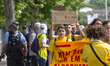 A demonstrator holds signs advocating for flights to stop at the protest from the Climaxim...