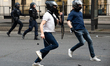 Paris Saint-Germain supporters celebrate and clash with police officers using tear gas nea...