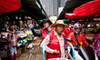 Shopping and delivery workers call for customers at Khlong Toey wet market in Bangkok, Tha...