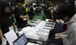 Election officials count early voting ballots at a ballot counting center set up at the Se...