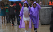 People wear raincoats to protect themselves from the heavy rain that lashes downtown Mexic...