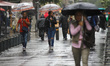 People use umbrellas to shield themselves from the heavy rain that lashes downtown Mexico...