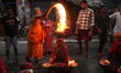 A woman holds earthen pots with fire during a ritual while worshipping Sheetala Mata, the...