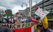 Protesters wave Palestinian flags and hold posters during the Global March to Gaza solidar...