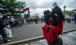 A cosplayer rests in front of a line of protesters who march during the global march to Ga...