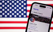 American flag displayed on a laptop screena and Donald Trump account on Truth Social displ...